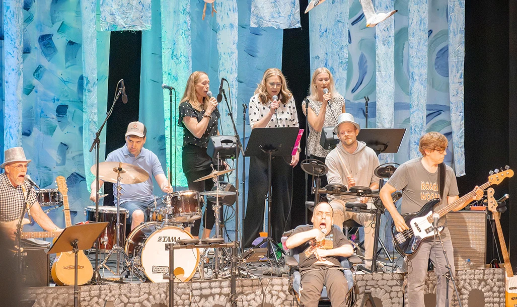 Människor som uppträder på scen med instrument