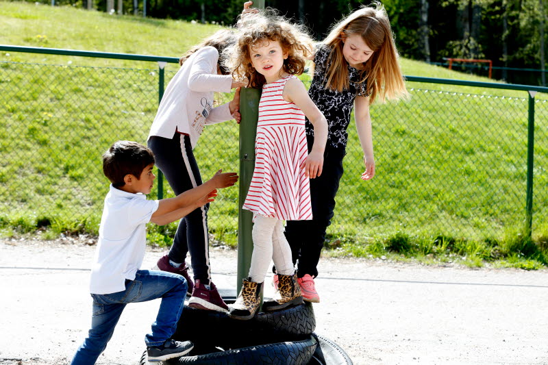 Fyra yngre barn som leker utomhus