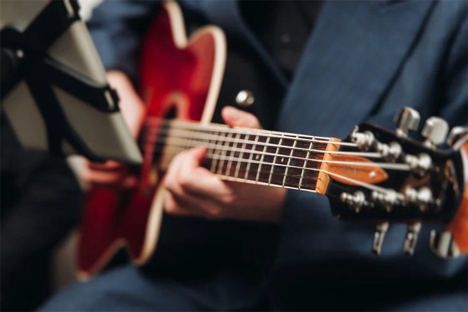 Närbild på person som tar ett ackord på gitarr.