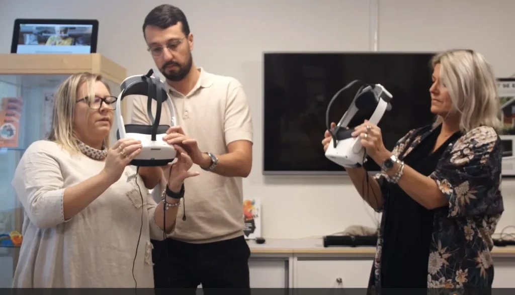 Två kvinnor och en man står med VR-utrustning i händerna