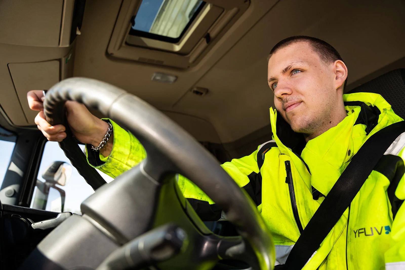 Elev jobbar på en dator bakom en motorhuv på en bil