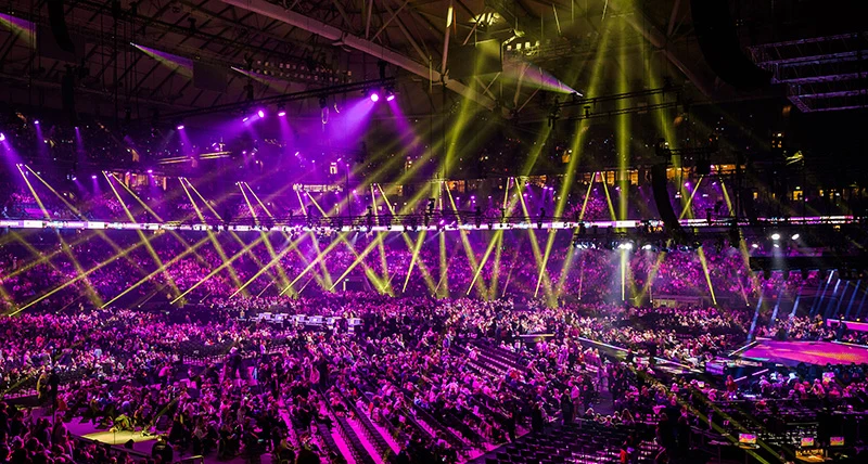 En stor mängd människor i en stor arena under ett evenemang.