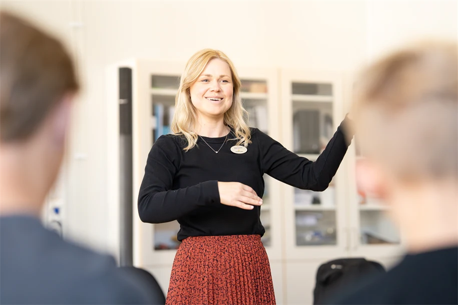 Kvinnlig lärare som står framför två elever