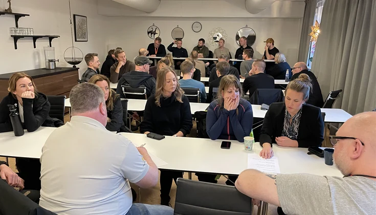 Grupper med flera personer runt ett bord. En i varje grupp antecknar.