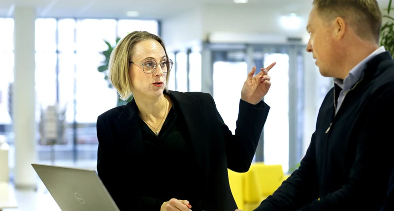 Kvinna gestikulerar och pekar i samtal med man.