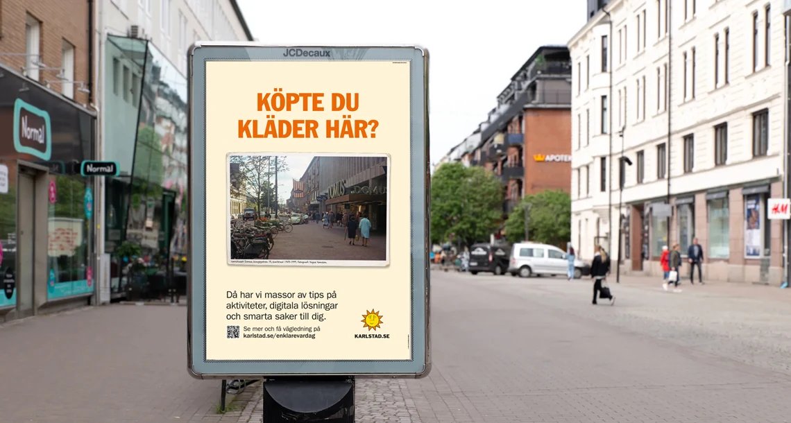 Stortavla i Karlstads centrum. Text på stortavlan: "Köpte du kläder här?". Under text är ett gammalt foto på Domus. Undertext: "Då har vi massor av tips på aktiviteter, digitala lösningar och smarta saker till dig." Länk: karlstad.se/enklarevardag