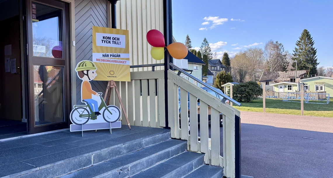 Skyltar och ballonger framför entré, vilka berättar att medborgarbudget pågår i lokalen.