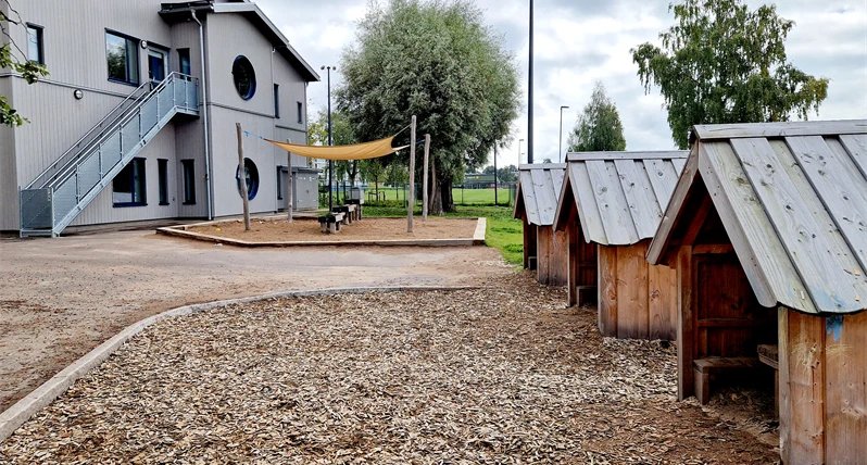 Utemijö på Orrholmens förskola, skokbyggnad och tre små lekhus