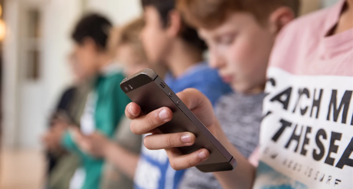 Elever som tittar i mobilen i skolmiljö