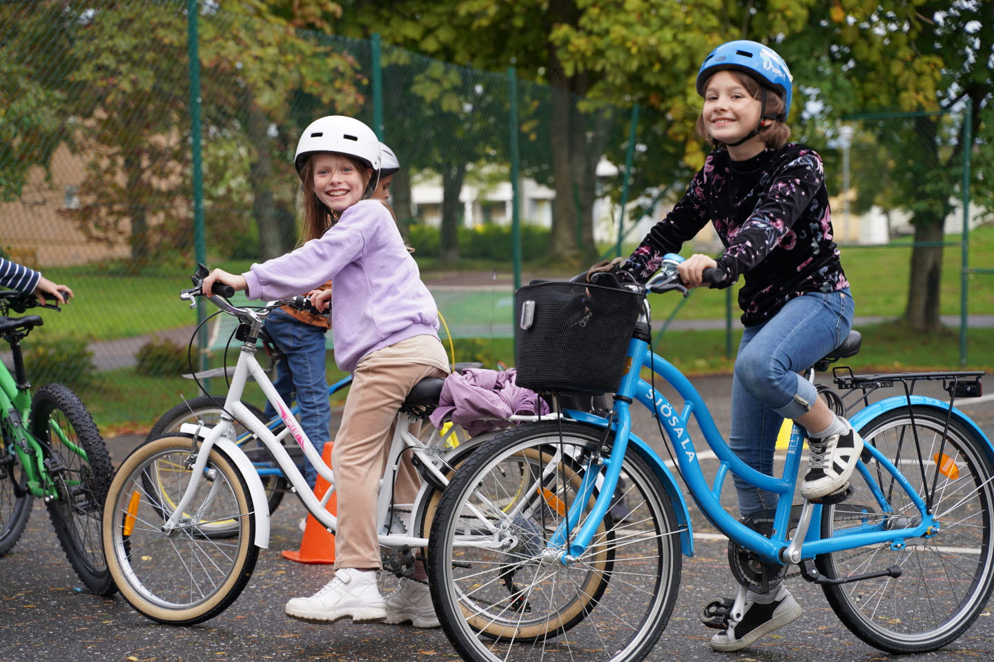 Två flickor står tillsammans med sina cyklar