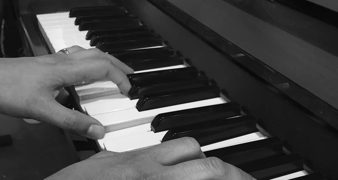 Händer på ett piano
