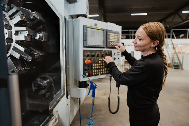 En person kör en CNC-maskin.