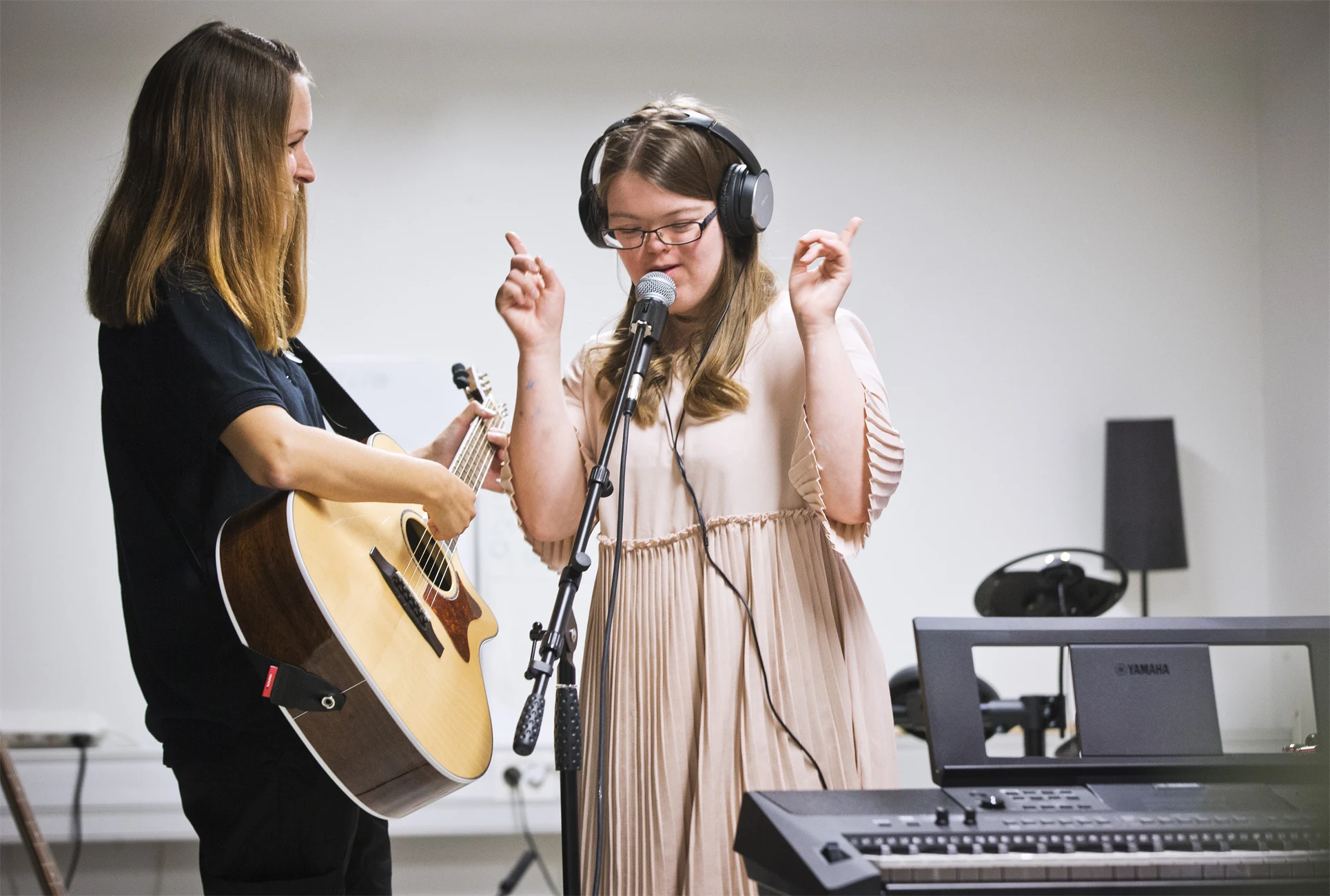 En ung kille som ger ett kompishandslag med en ung kille med downs syndrom.