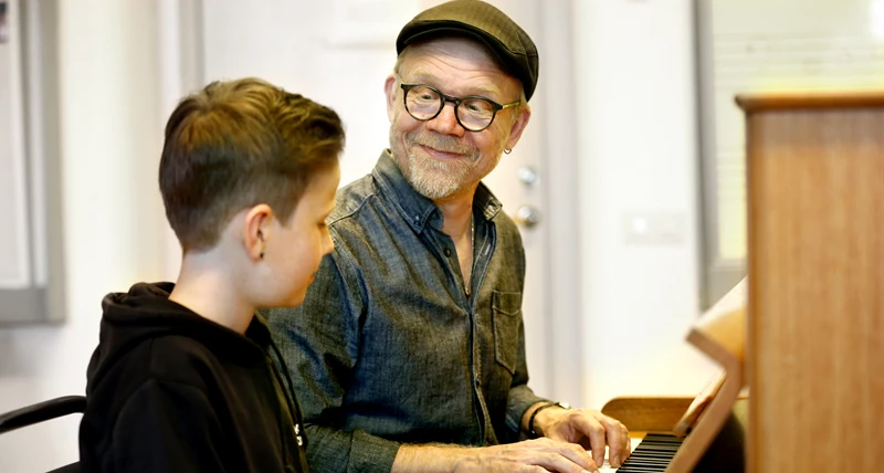 Lärare och elev som spelar piano