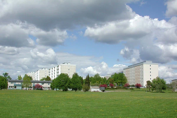 En grönyta med vita och beige lägenhetshus i bakgrunden