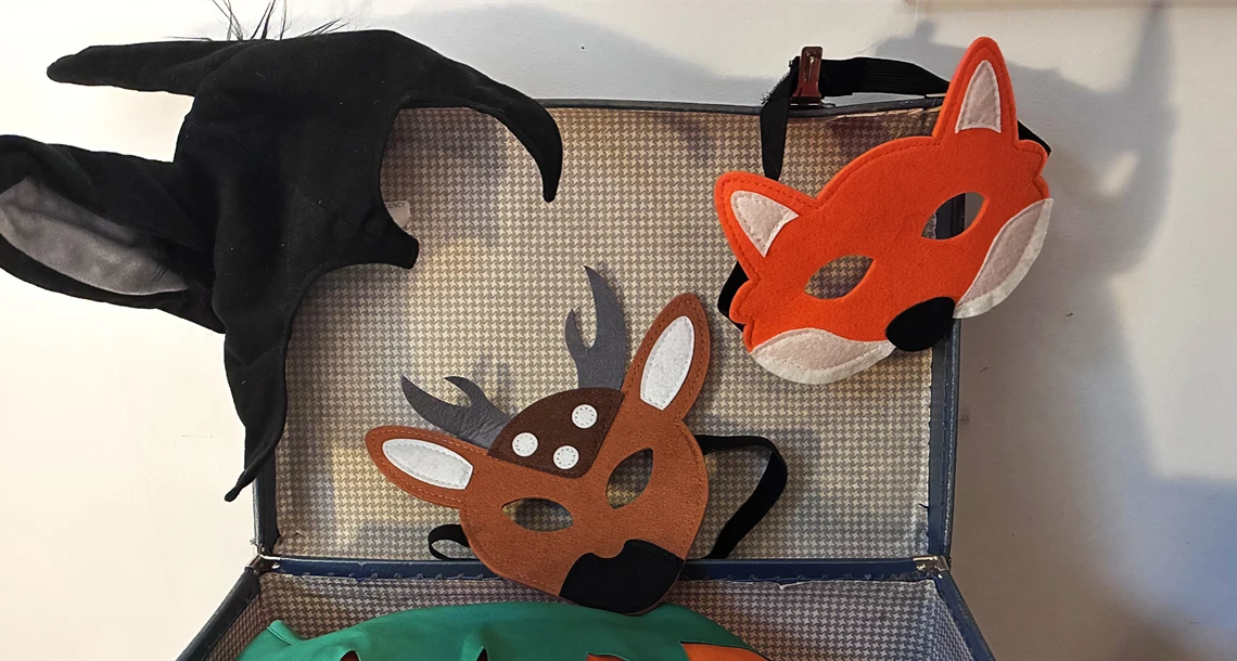 Låda med teatermasker och tyg