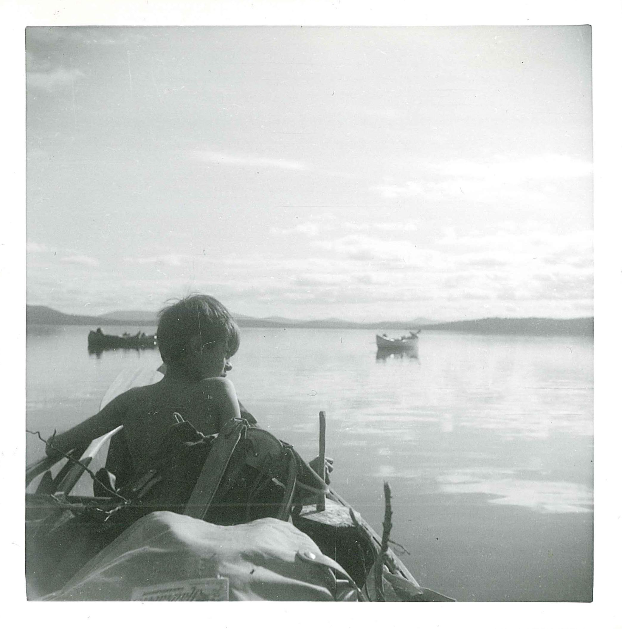 Pojke i kanot tittar ut över sjö