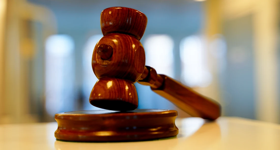 En ordförandeklubba i trä ligger på ett bord.