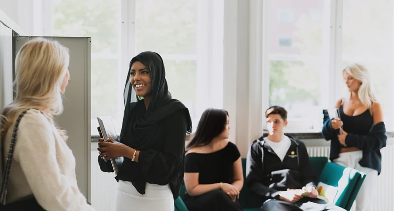 Gymnasieelever pratar med varandra i korridoren på Tingvallagymnasiet.