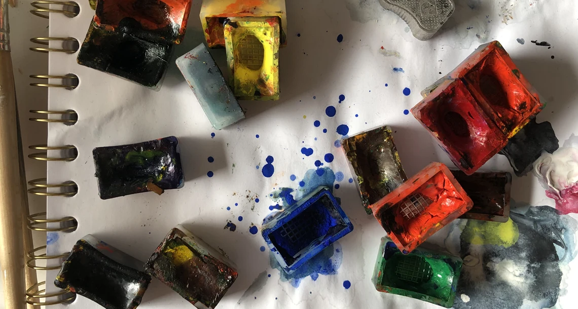 Person sträcker sig efter penslar