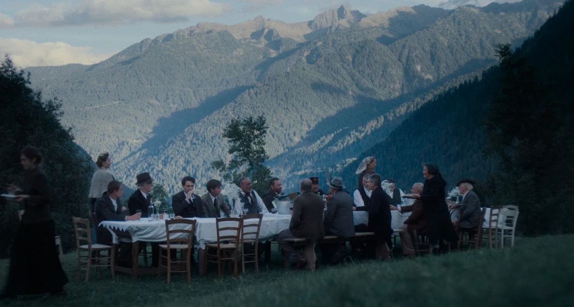 Flera personer sitter runt ett bord i alperna.