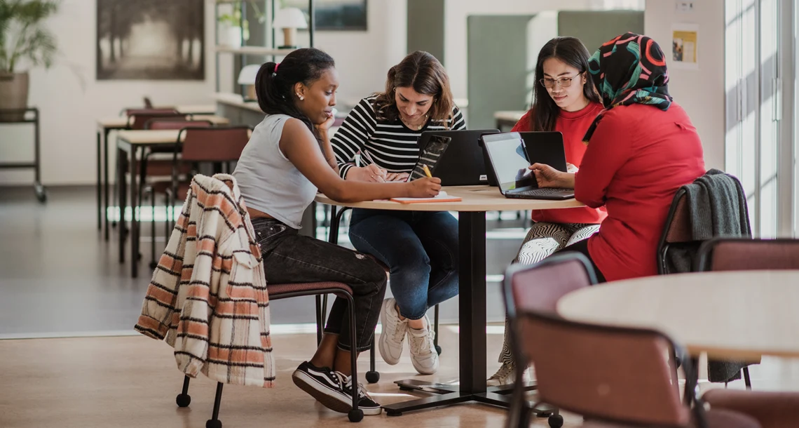 Bild på fyra vuxenstuderande elever runt ett bord som studerar på Tingvalla