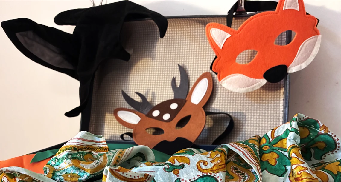 Låda med teatermasker och tyg
