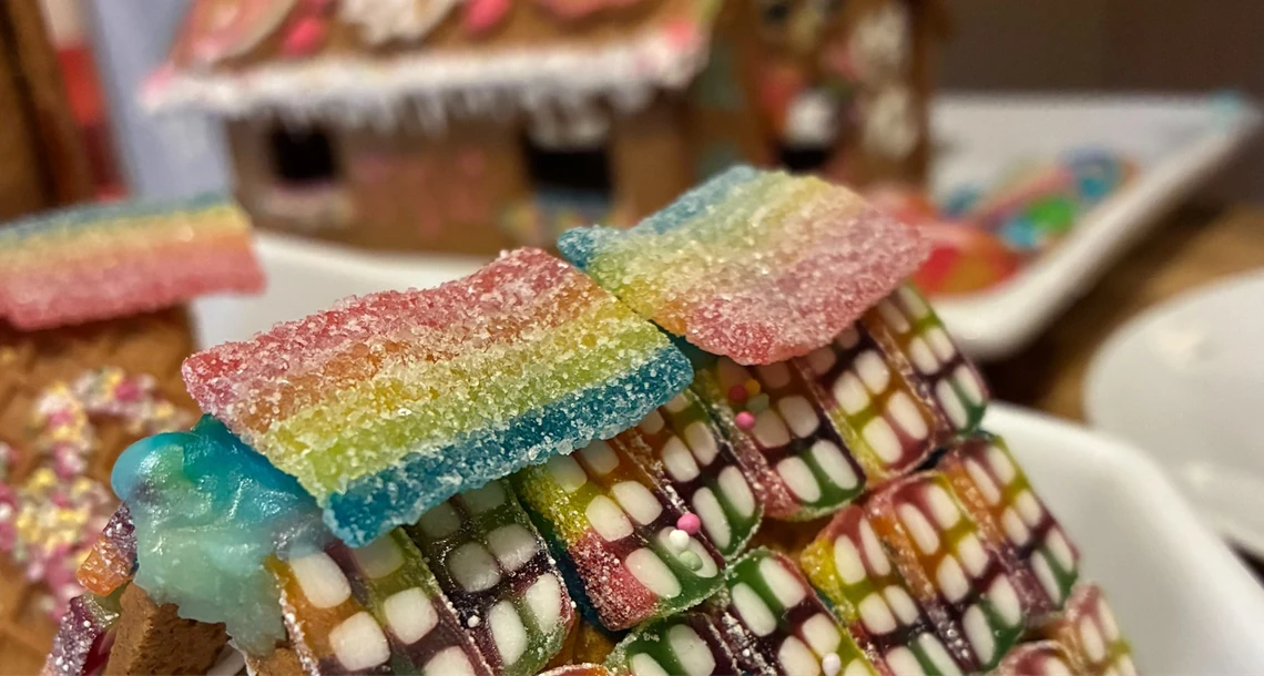 Närbild på ett pepparkakshus dekorerat med godis