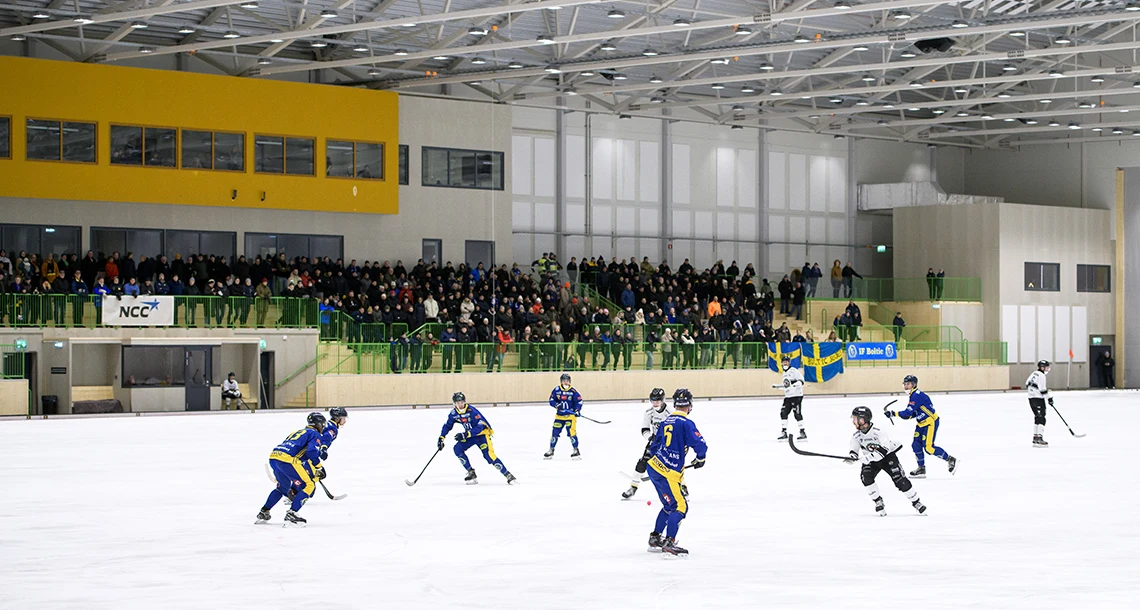 Två lag möts i en bandymatch i en inomhusarena.