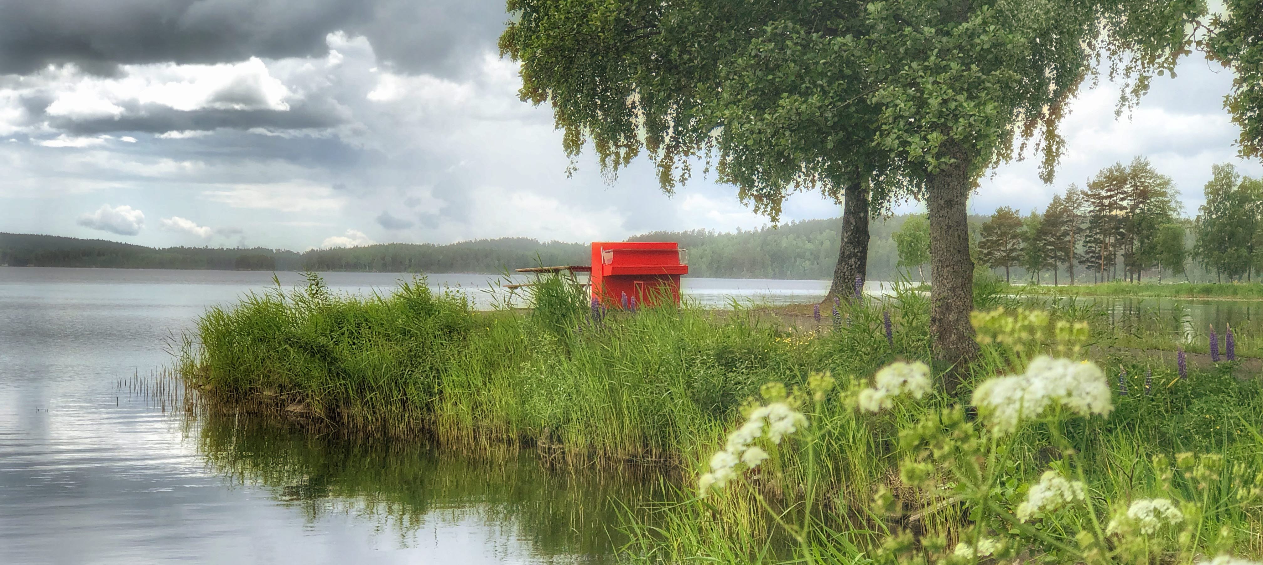 Röd piano intill en sjö