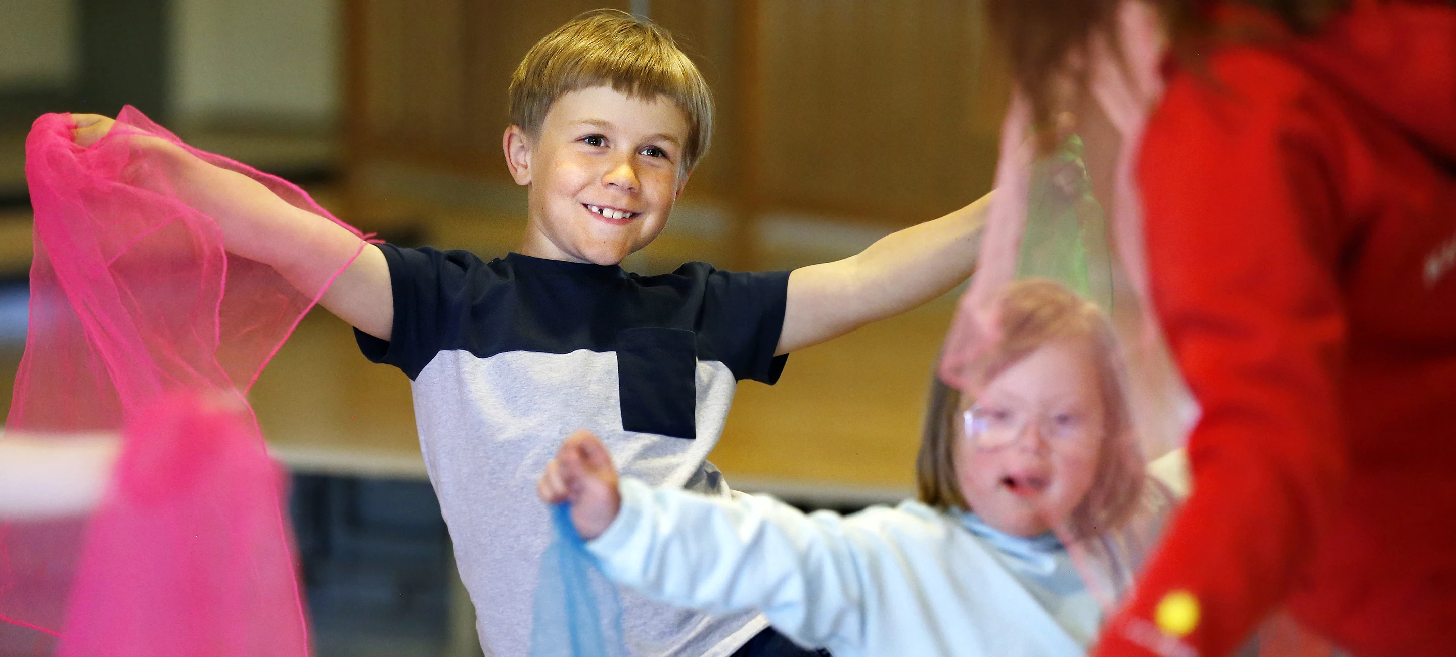 Pojke och flicka som dansar med pompoms tillsammans med en lärare från Kulturskolan