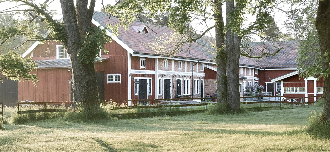 En husfasad med en uteservering framför tagen på kvällen.