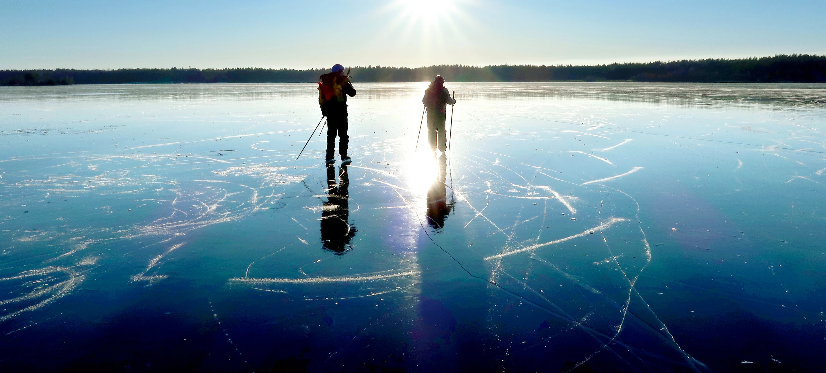 Skridskoåkare på isen i solljus