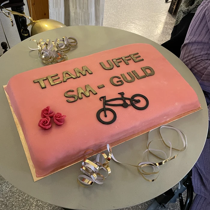 Tårta med text "Team Uffe SM-guld" och en cykel i marzipan.