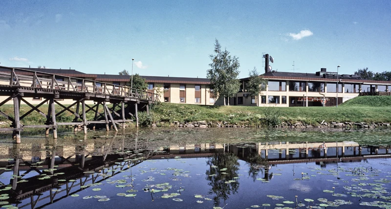 En bred husfasad med vatten i förgrunden