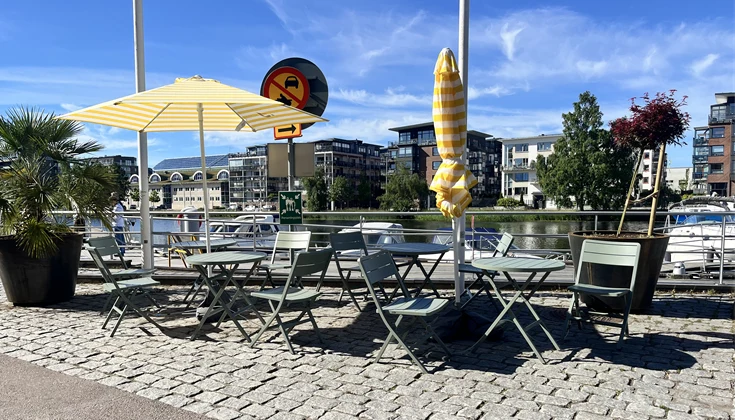 Bord och stolar som står på gatan intill vattnet i Inre hamn