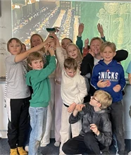 En grupp yngre elever som håller upp en pokal