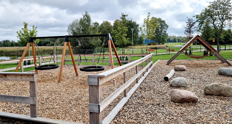 Skolgård med gungor, stenar och en klättervägg