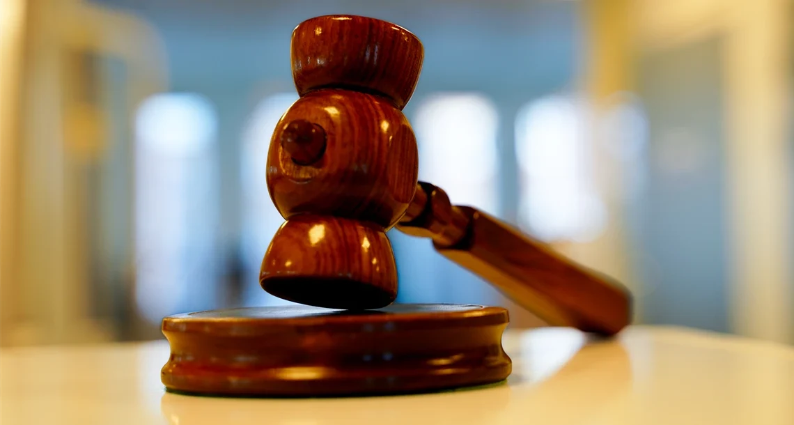 En ordförandeklubba i trä som ligger på ett bord.