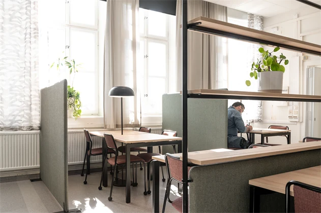Studiemiljö på Lärcenter med stolar och bord. En elev studerar.