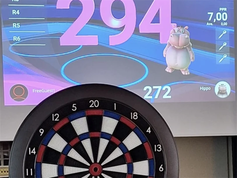 Digital darttavla med resultat på storbild i bakgrunden