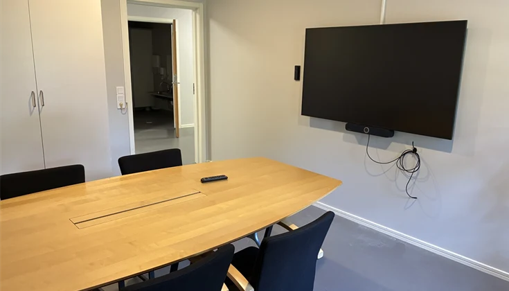 Mötesrum med bord, stolar och skärm