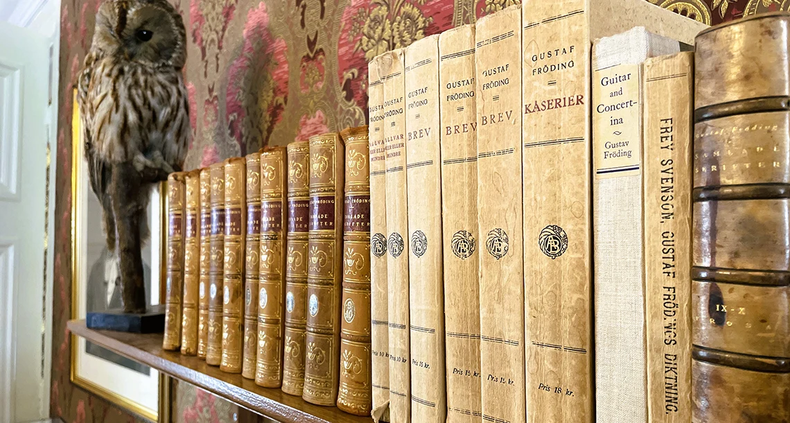 Äldre uppställda Frödingböcker i salongsmiljö