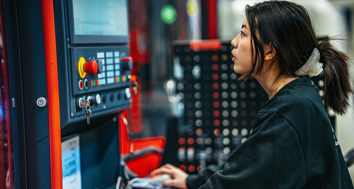 En person kör en CNC-maskin.