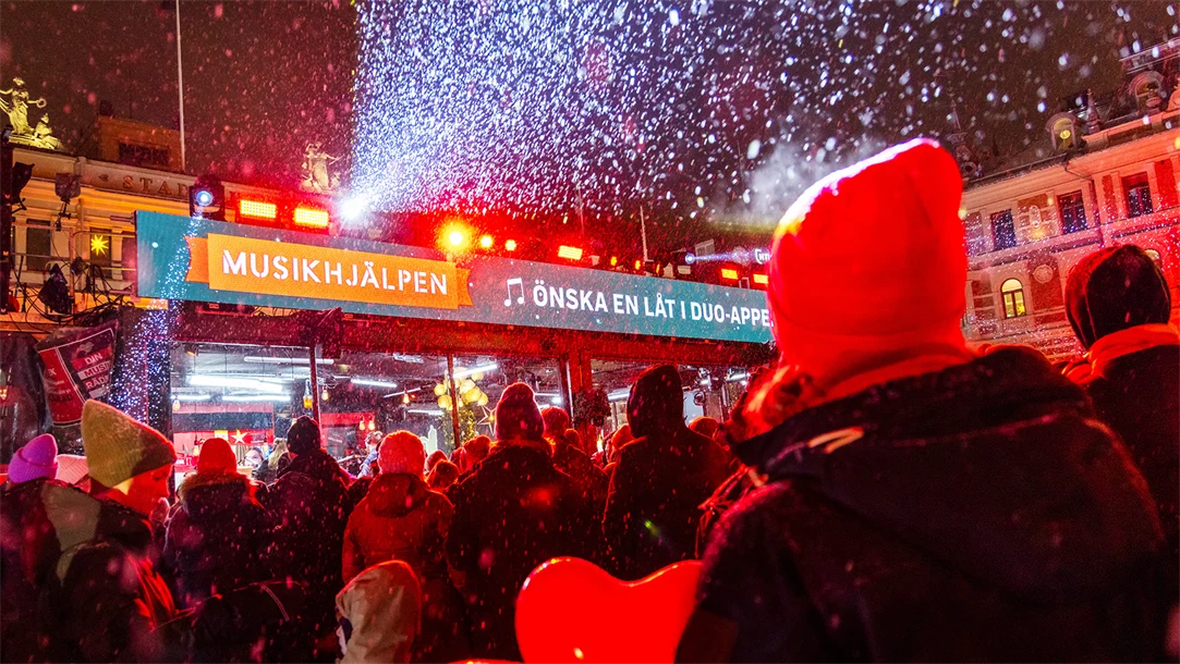 Buren med texten Musikhjälpen med publik framför.