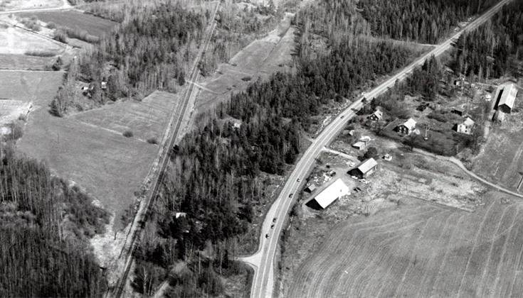 Ett svartvitt flygfoto över Knappstad där du ser skog och några hus