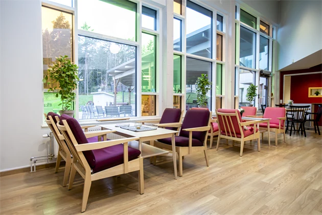 Loungegrupper intill stora fönster med flerfärgat glas som ger ett rejält ljusinsläpp