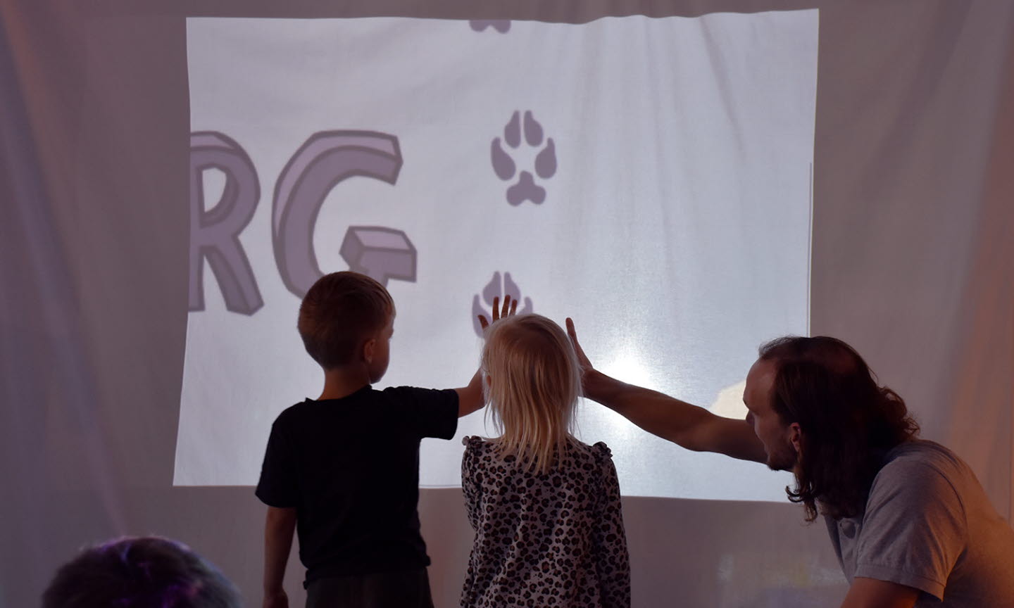 Förskolebarn jämför sina händer med ett lodjurs på en skärm