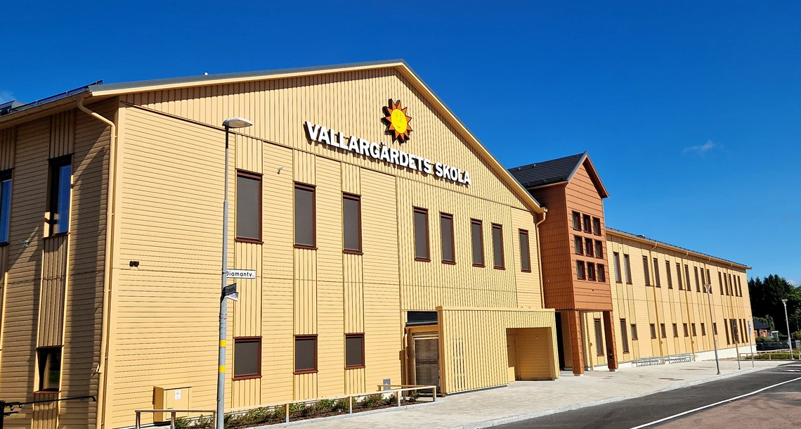 Framsidan på vallargärdet skola - byggnad i gulaktigt trä