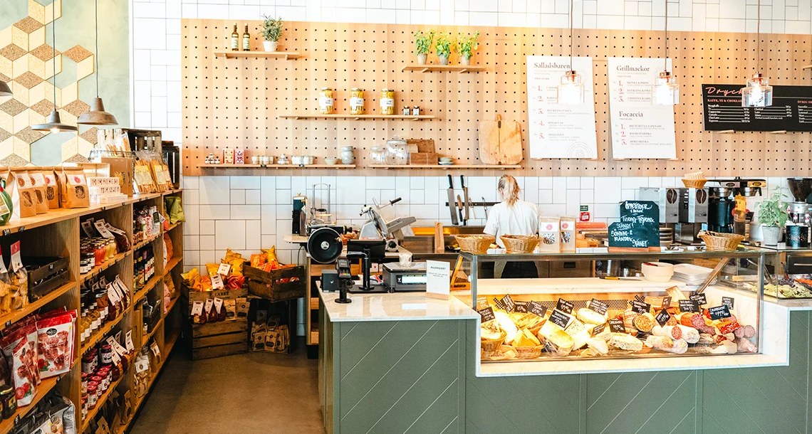 En disk och flera hyllor med ostar och charkuterier